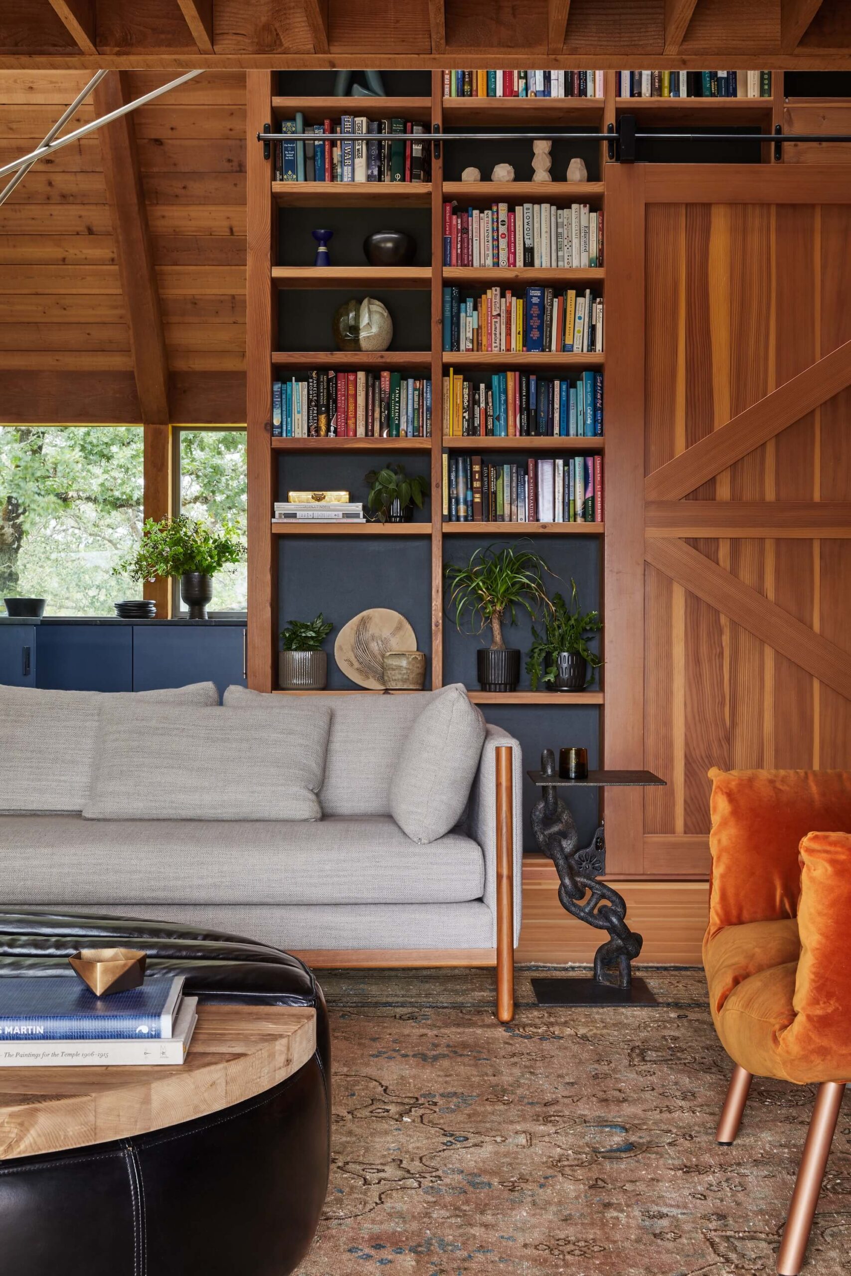 Living room with modern furniture, wood paneling, high ceilings